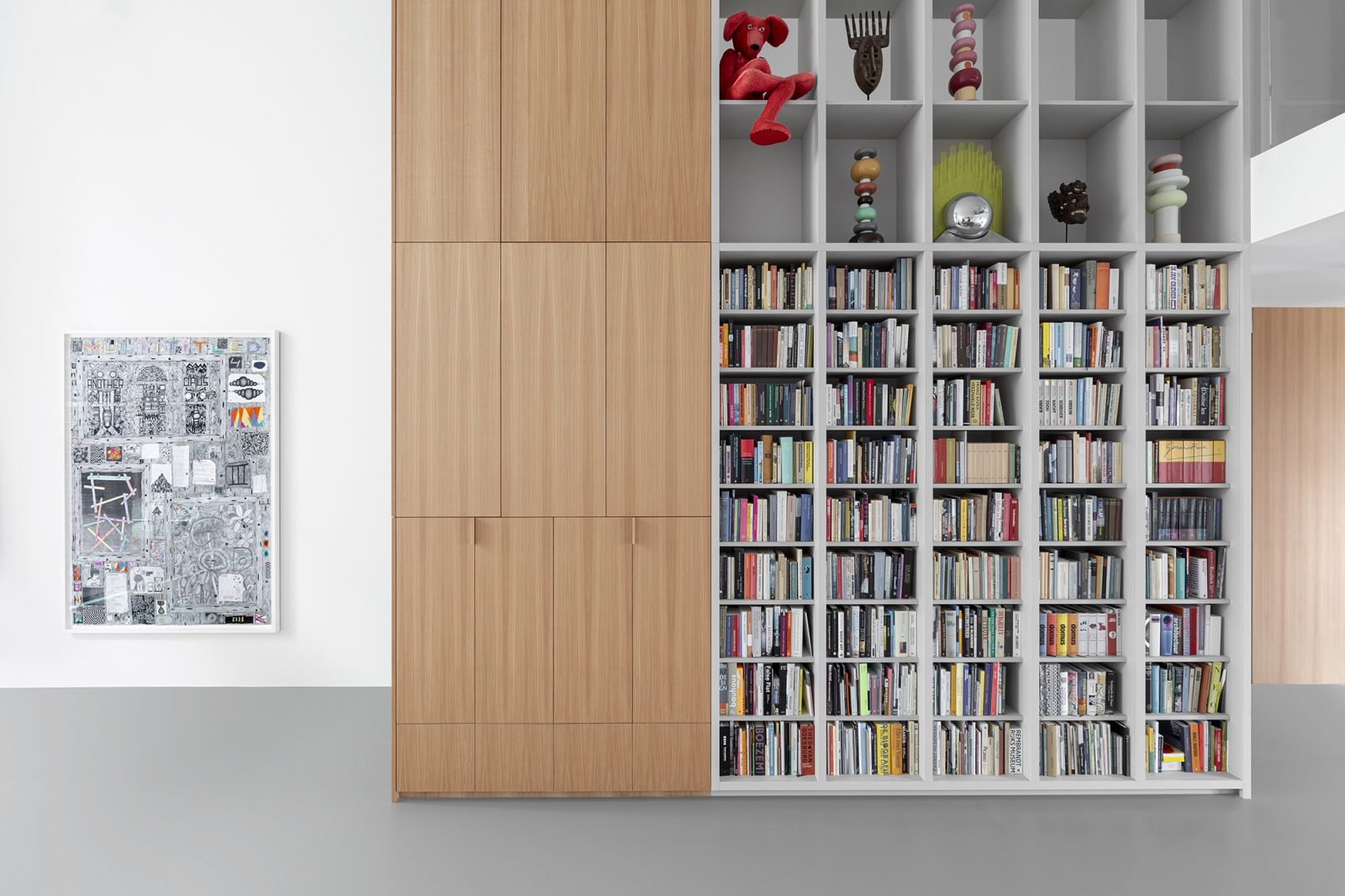 Bibliotheekwand met grijze open kasten en houten kastdeuren