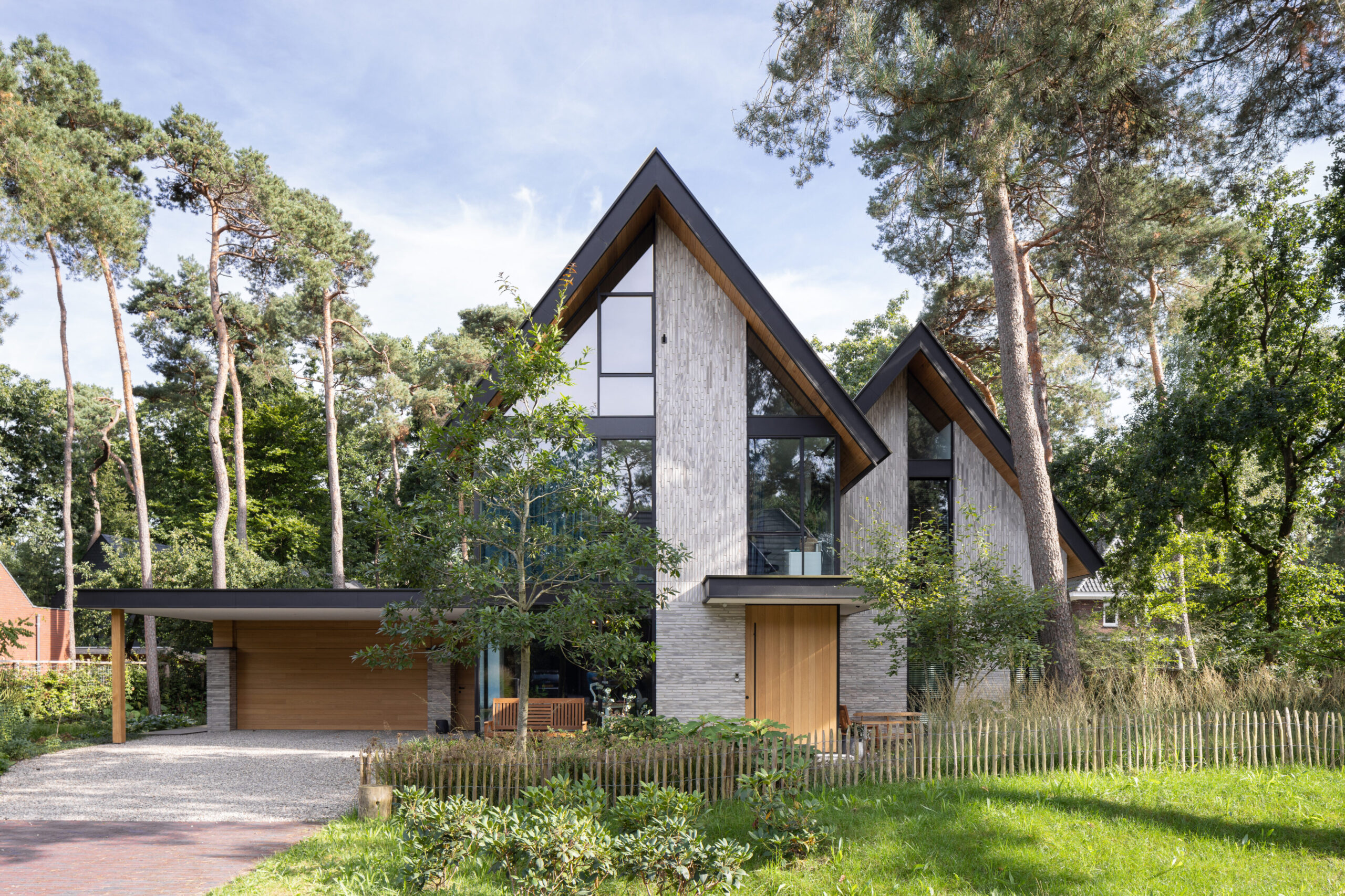 Moderne villa met witte baksteengevel, houten garagedeur en oprit