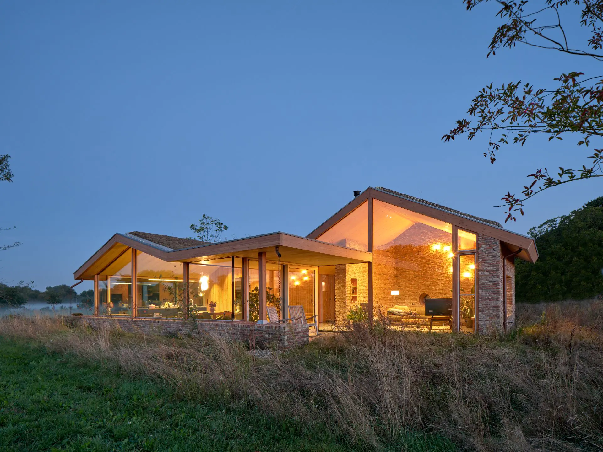 Avondopname moderne woning met houten veranda en bakstenen muurfacade
