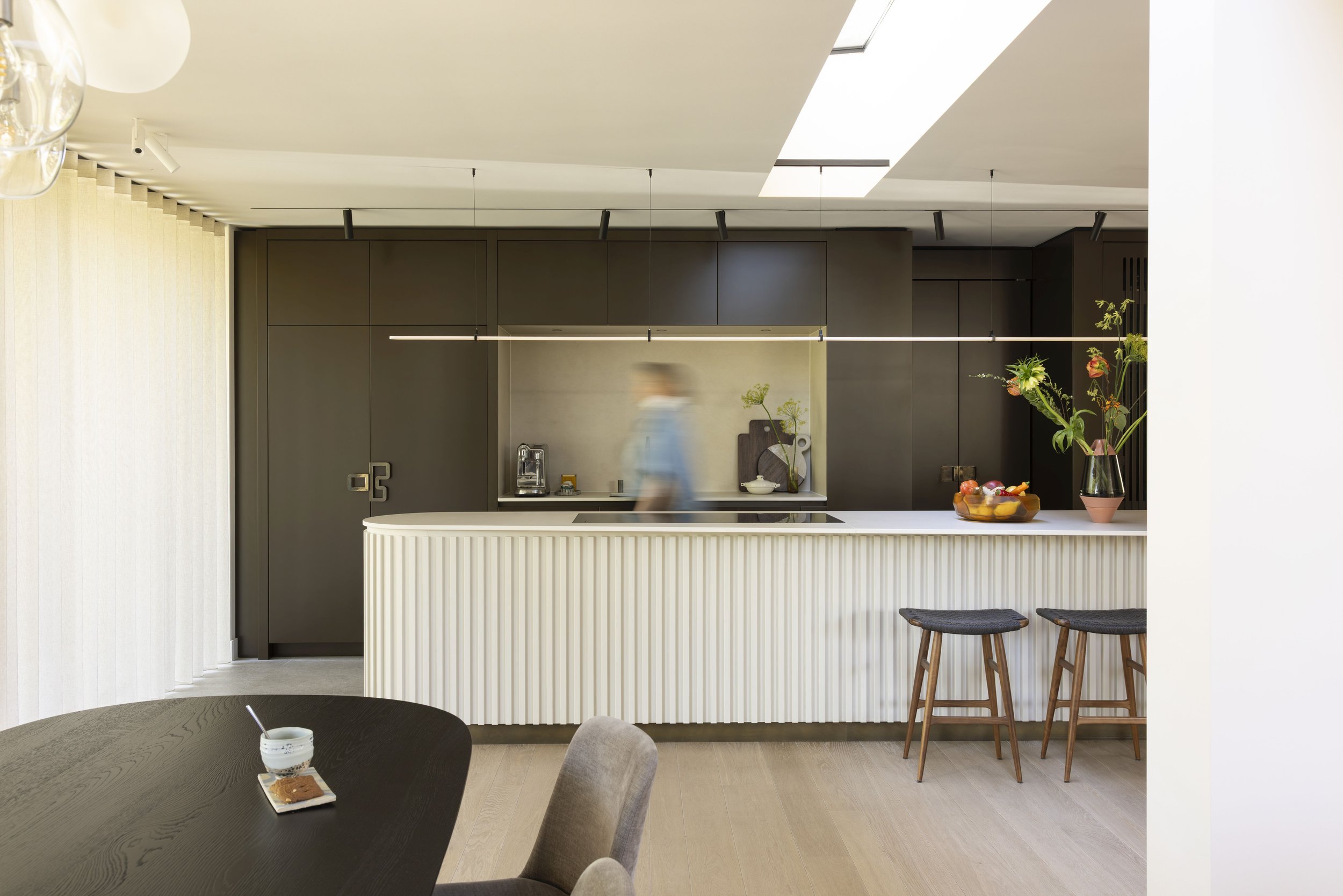 Keuken met grijze gestructureerde kasten en hangende glazen verlichting
