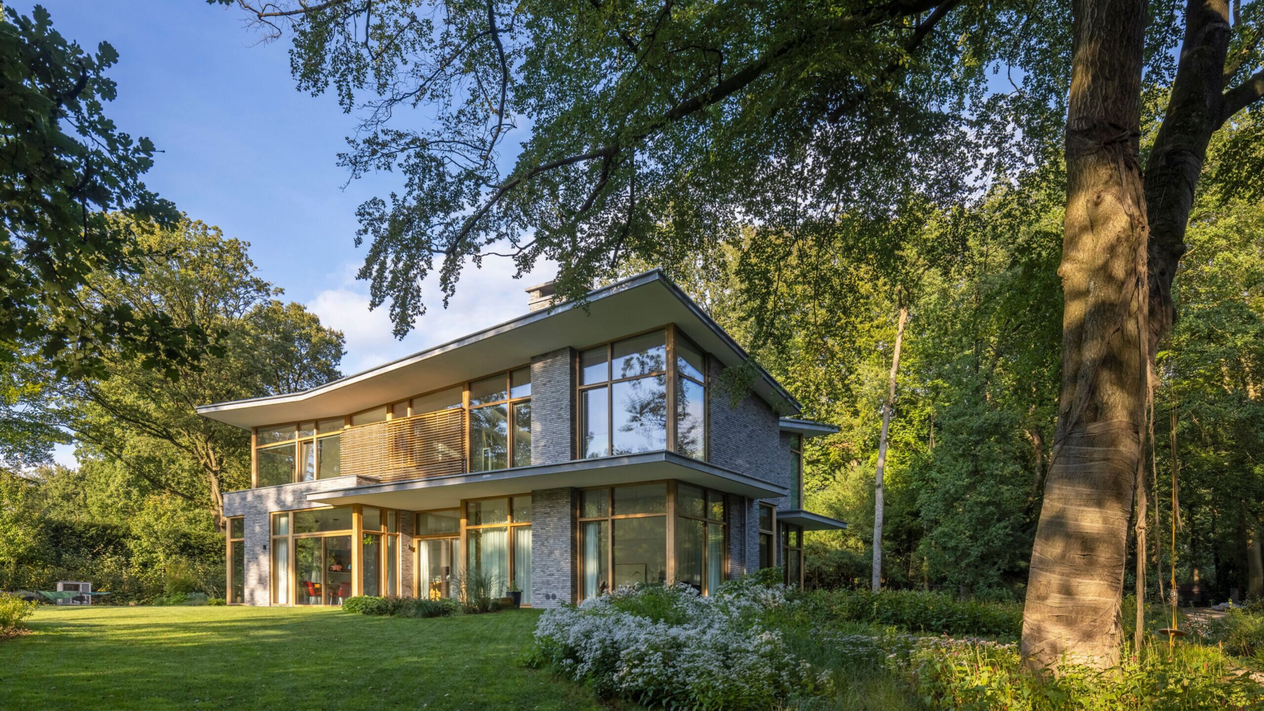 Moderne twee-etage woning met grijs baksteenwerk en grote raamvlakken
