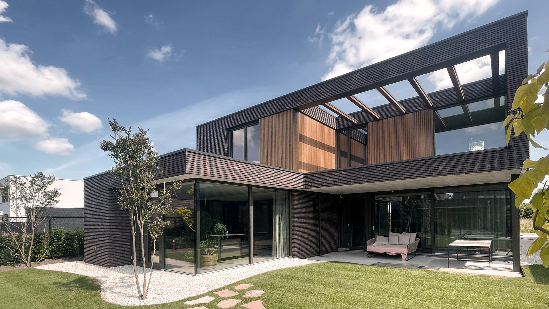 Moderne villa met donkere baksteengevels, houten accenten en terras