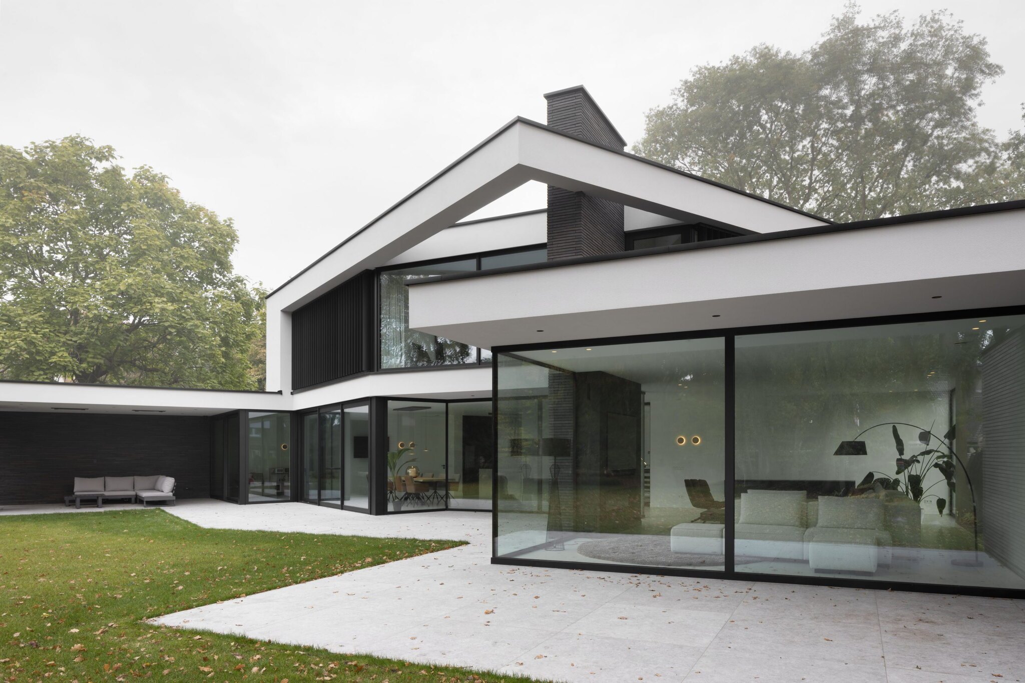 Hedendaagse woning met zwart houtwerk, witte accenten en grote glazen schuifpuien