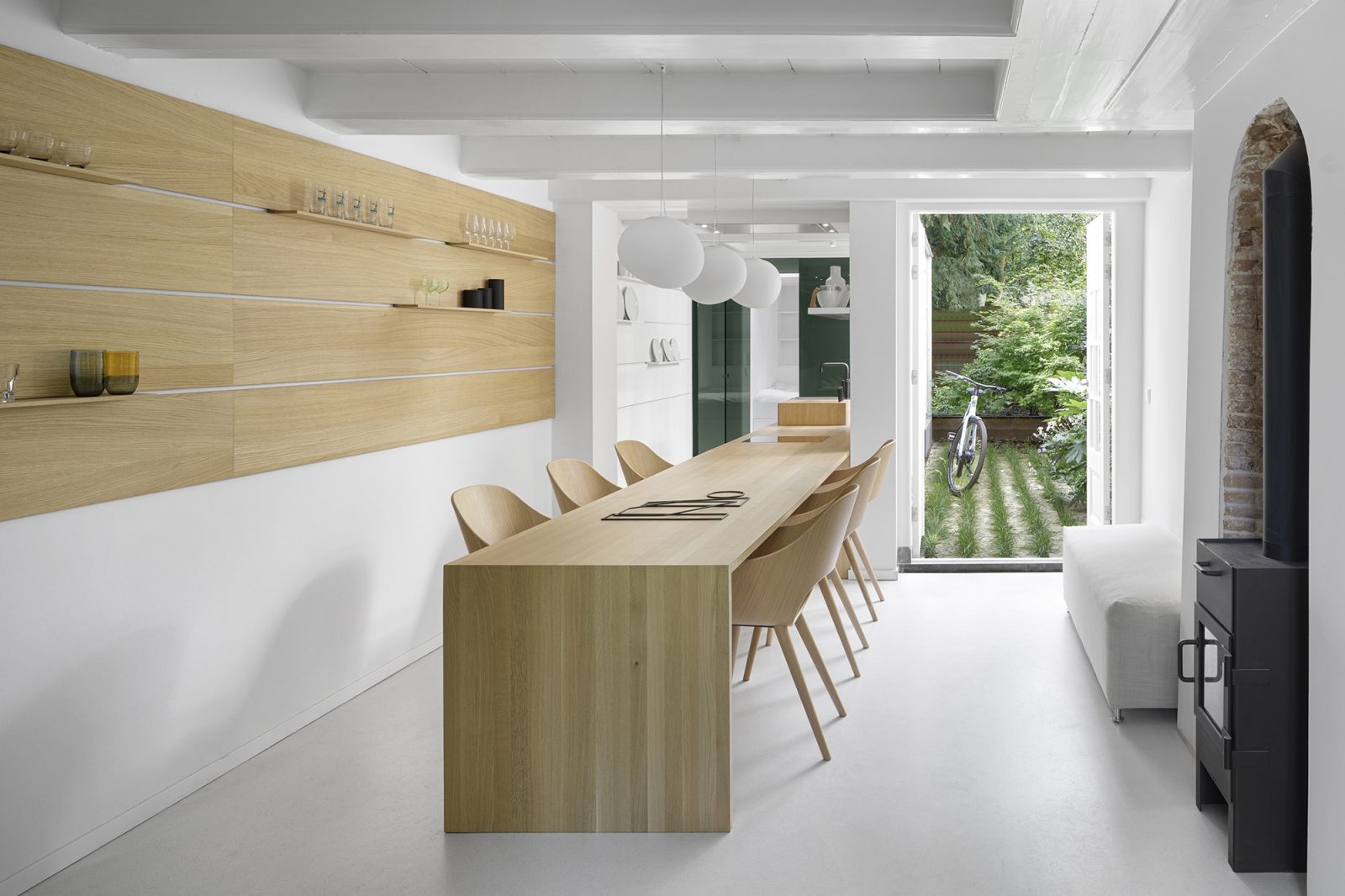 Open keuken met houten werkblad, witte kasten en uitkijkraam op tuin