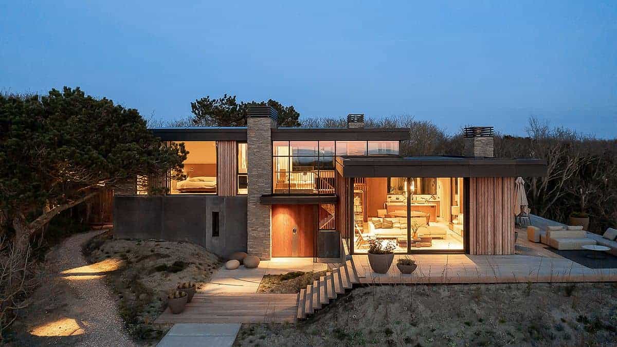 Moderne strandvilla met houten cladding en metalen toegangspoort